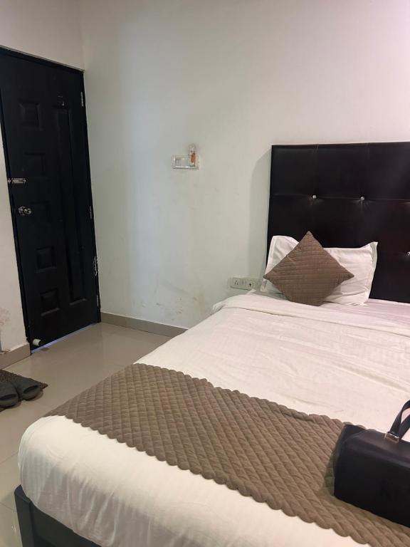 卡兰古特The Balaji inn Baga的卧室里有一张带黑色床头板的大床