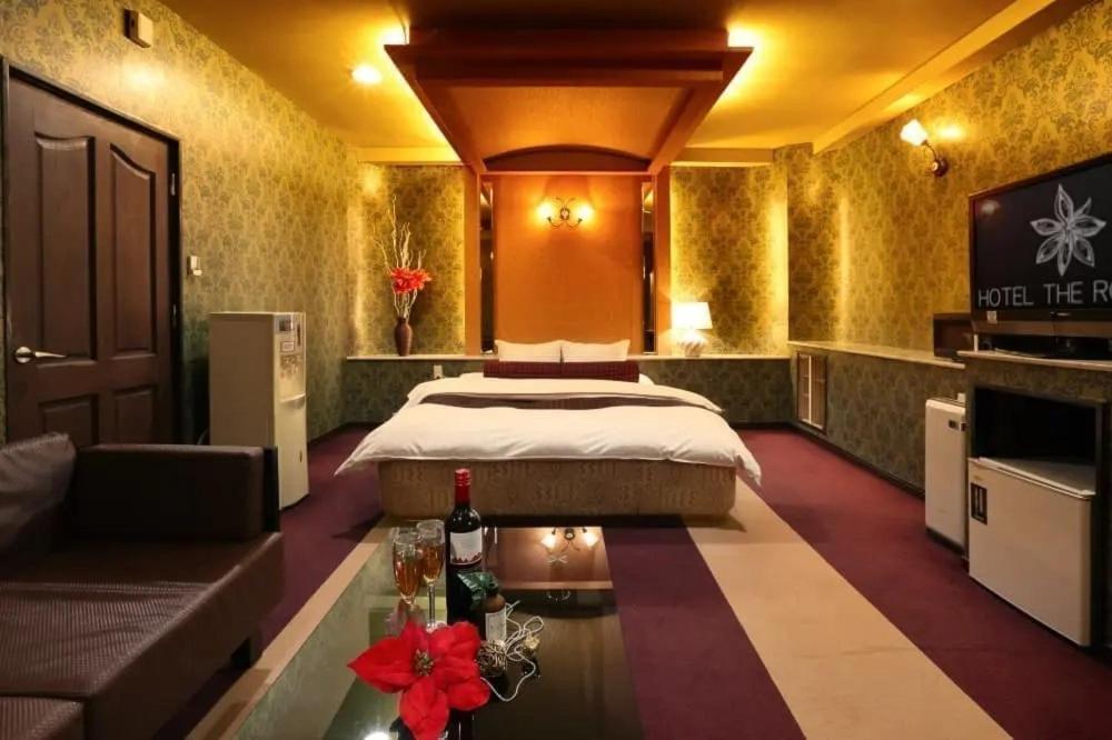 别府HOTEL the ROOMS - Couple's Hotel的酒店客房,配有床和沙发