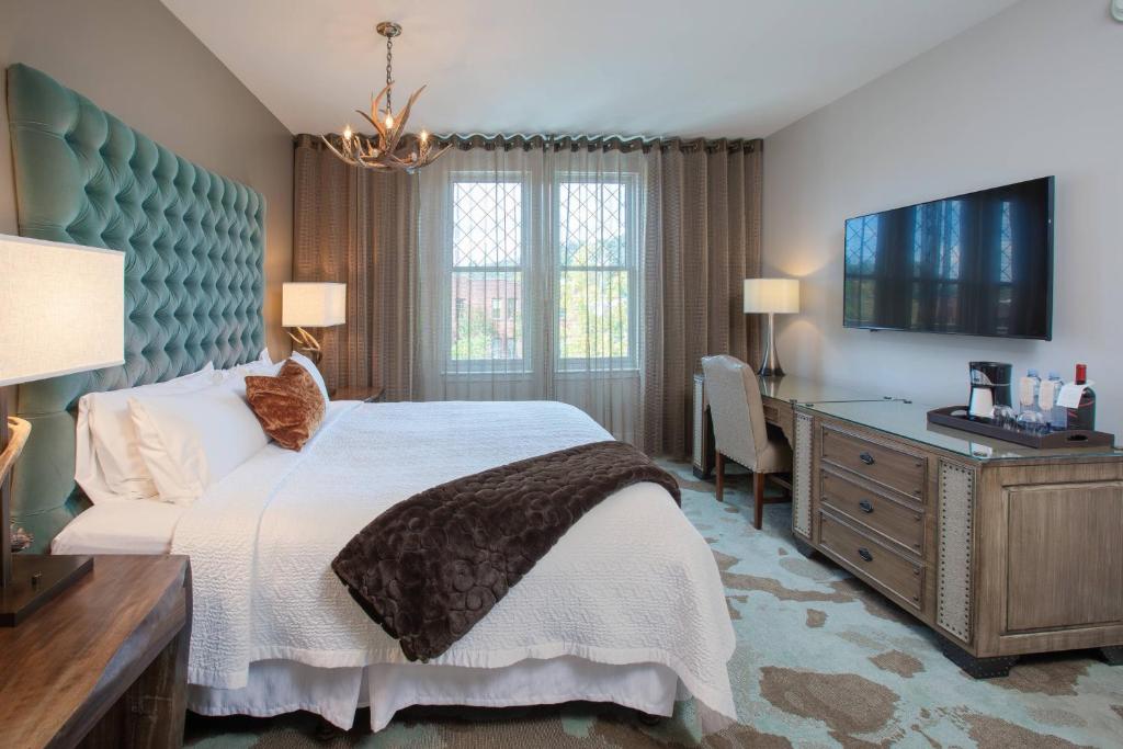 阿什维尔奥托格拉夫系列阿什维尔波西米亚大酒店的一间卧室配有一张床、一张书桌和一台电视