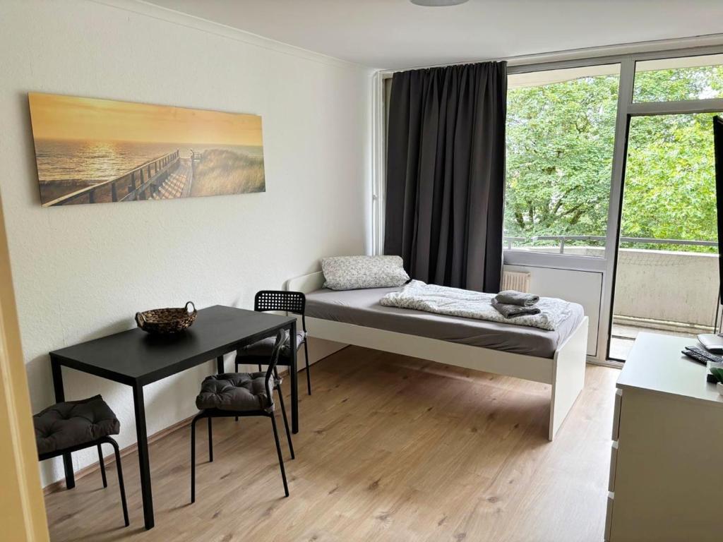 科隆Monteurwohnung in Köln-Kalk的客房设有床、桌子和窗户。