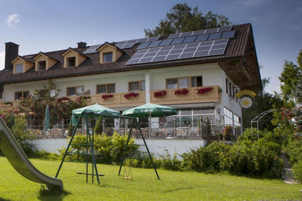 萨尔道夫阳光之家宾馆的屋顶上设有太阳能电池板和滑梯的房子
