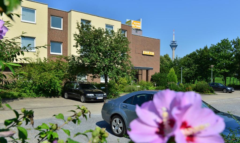 杜塞尔多夫艾斯特拉酒店的把车停在一个布满紫色花的停车场