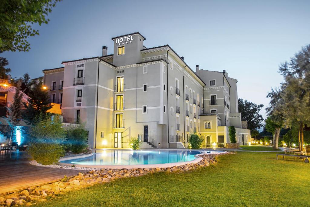阿拉贡省阿拉马阿拉贡省巴尔内阿里奥阿拉马酒店的一座大型建筑,前面设有一个游泳池