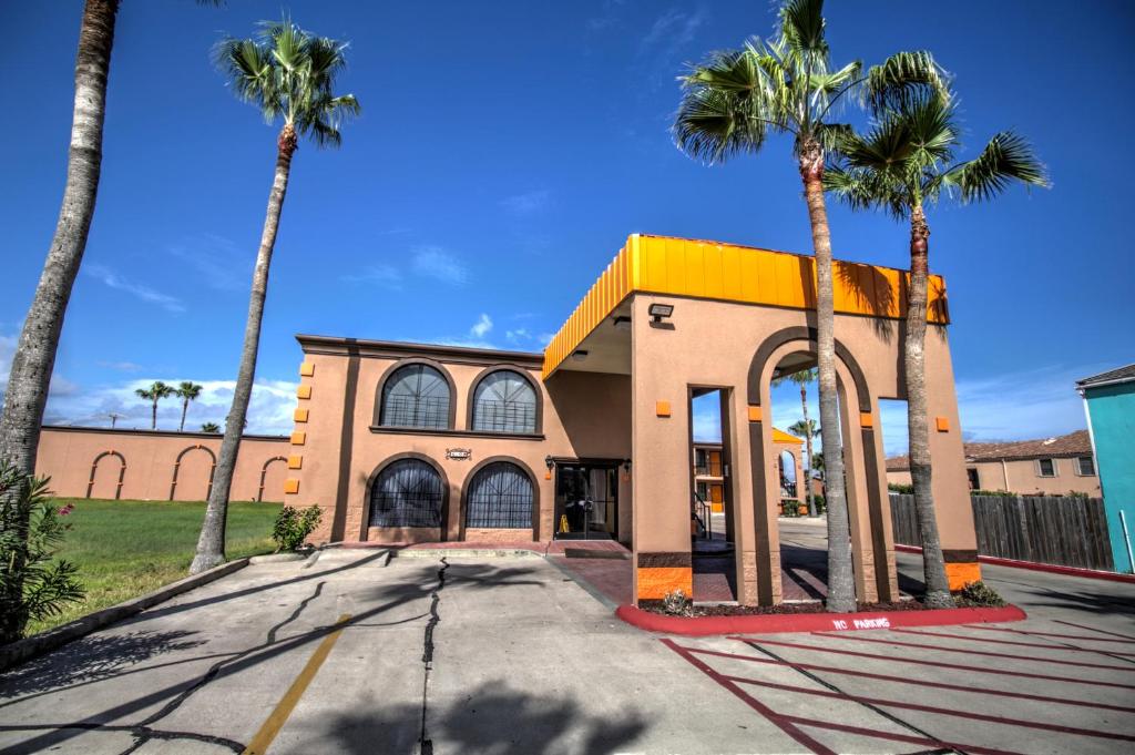 南帕诸岛South Padre Island Inn的一座前面有棕榈树的建筑