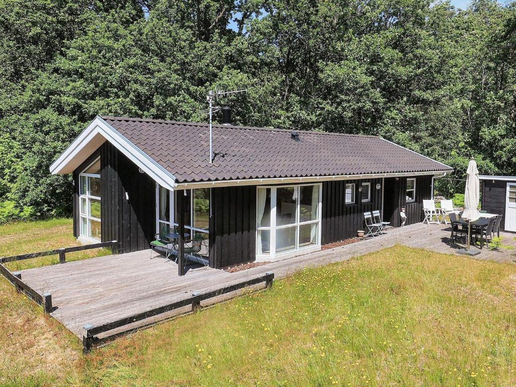 莱斯Holiday home Læsø IV的一个带甲板的黑色小小屋