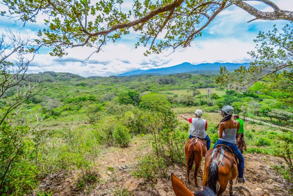 TanquesVida Aventura Ranch的两人在山区的路径上骑马