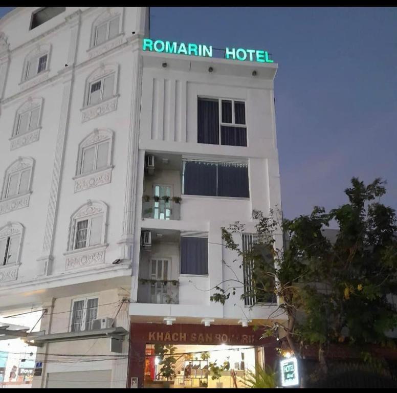 胡志明市Romarin Hotel的白色的建筑,上面有标志