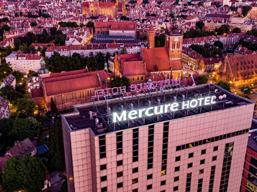 格但斯克Mercure Gdańsk Stare Miasto的建筑物顶部地铁酒店标志的图象