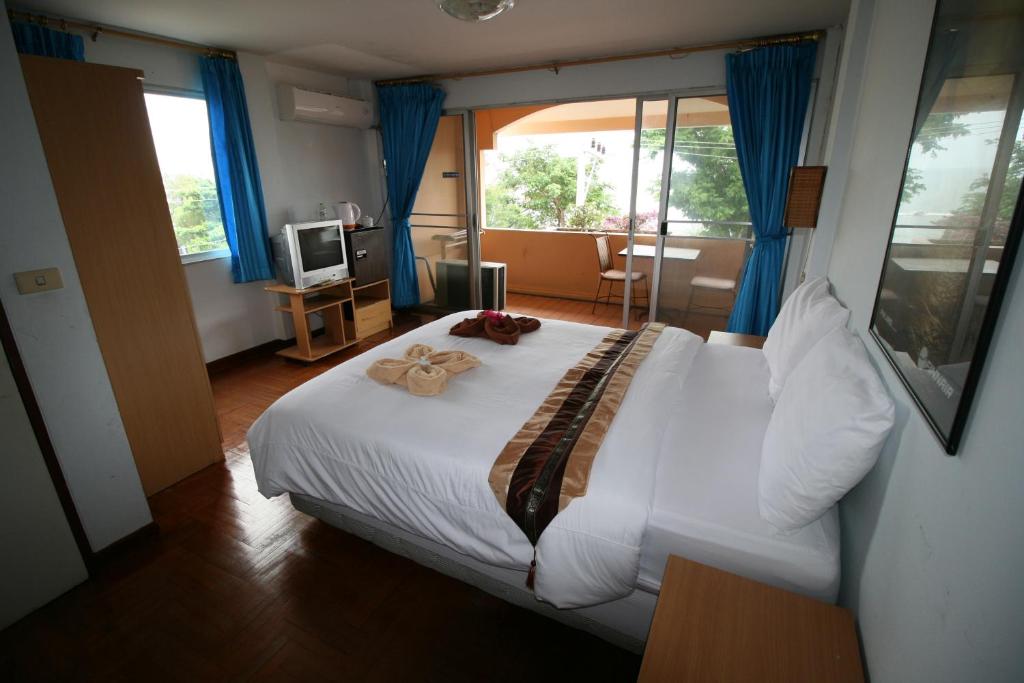 七岩七岩海滨酒店的一间卧室配有一张大白色的床,上面有两朵玫瑰花