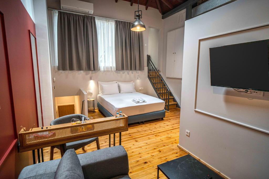 雅典Belle Athenes - Luxury Rooms at Monastiraki Railway Station的配有一张床和一台平面电视的酒店客房