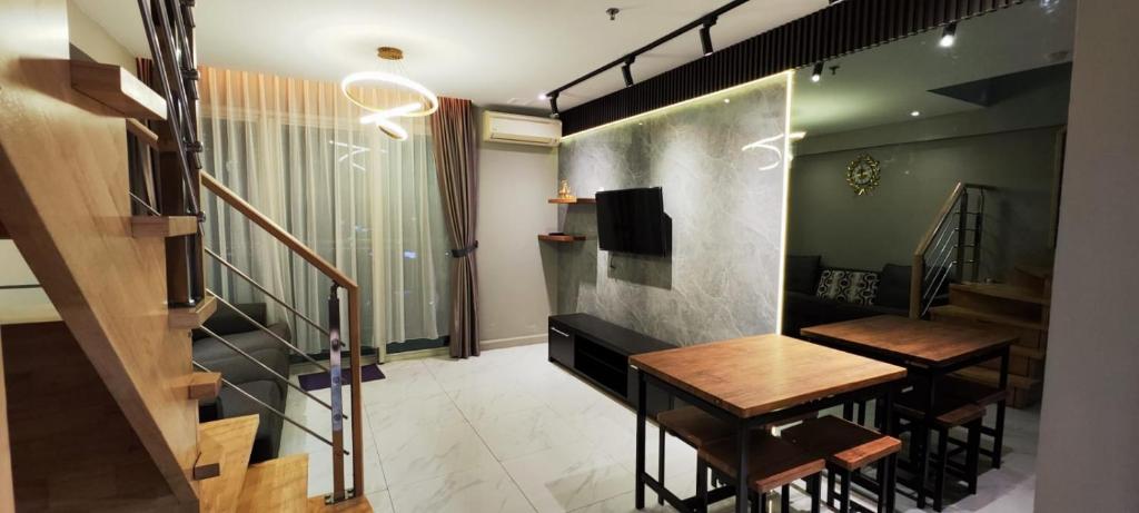 棉兰2 BR Apartment Grand Jati Junction Medan view City 12th Floor的带2张凳子和桌子及楼梯的房间