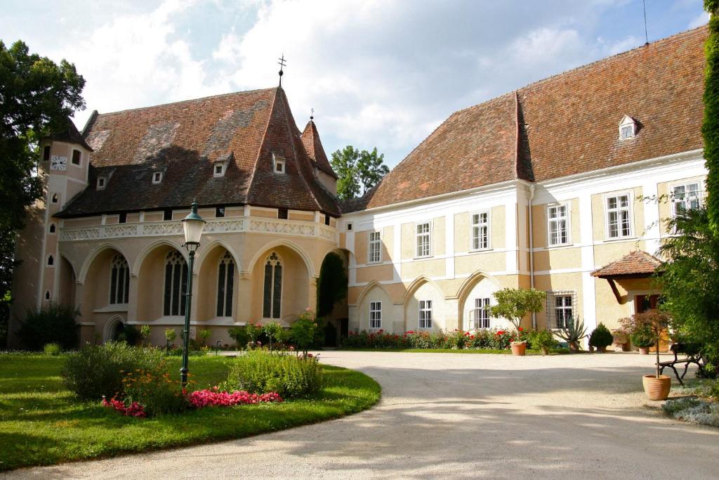 SchrattenthalSchloss Schrattenthal的白色的大建筑,带有棕色的屋顶