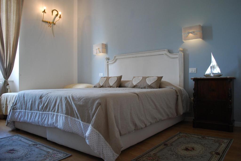 利沃诺短笛海军旅馆的一间卧室配有一张带白色床头板的大床