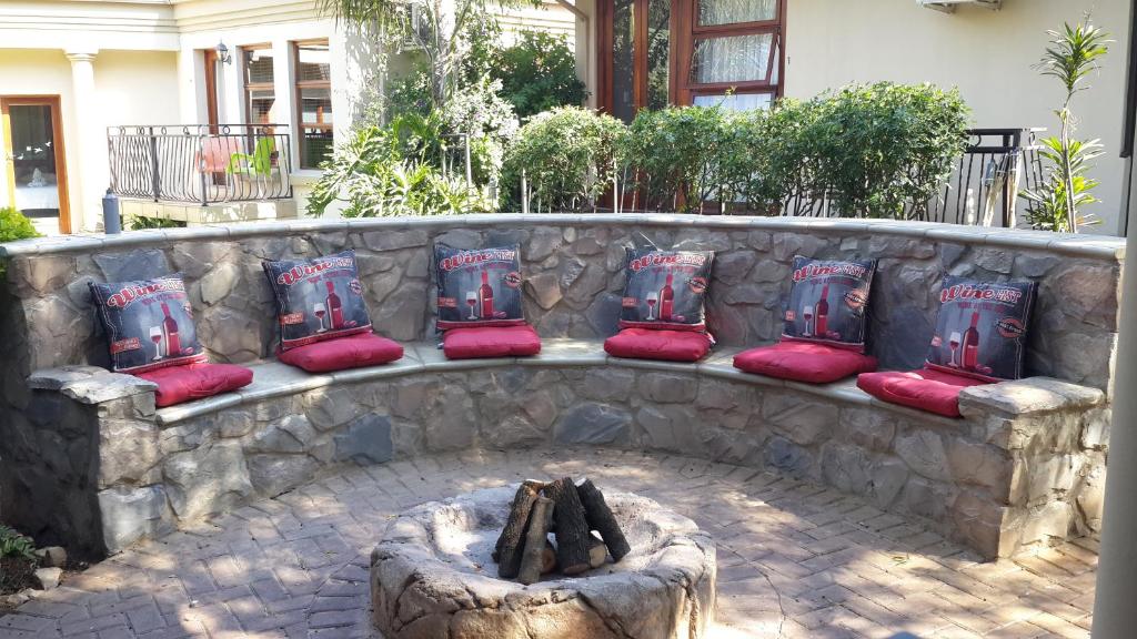 肯普顿帕克老鹰岩行政旅馆的石头长凳,配有红色靠垫和火坑