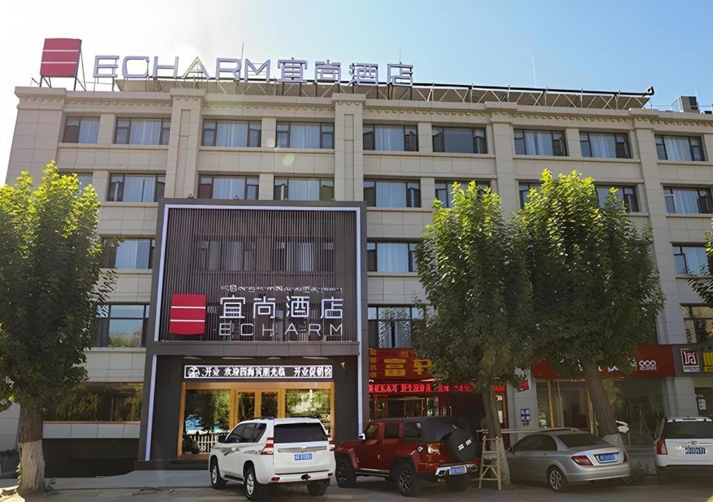 拉萨Echarm Hotel Lhasa Potala Palace的前面有汽车停放的建筑