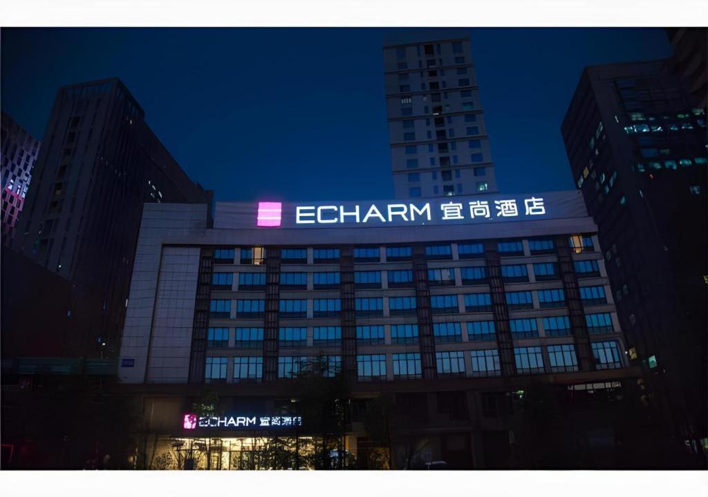 贵阳Echarm Hotel Guiyang City Hall Lincheng Xi Road Metro Station的一座建筑物,上面有夜间标志