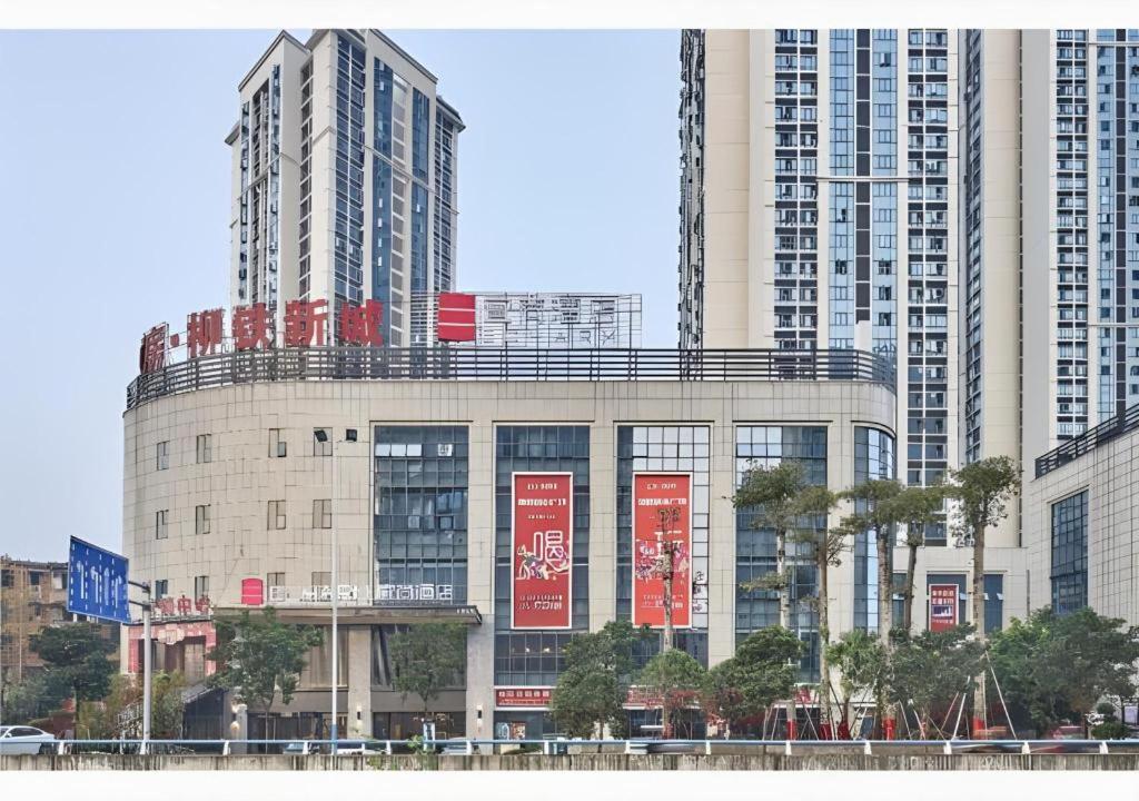 柳州Echarm Hotel Liuzhou High-speed Railway Station的一座高楼前有红色标志的建筑