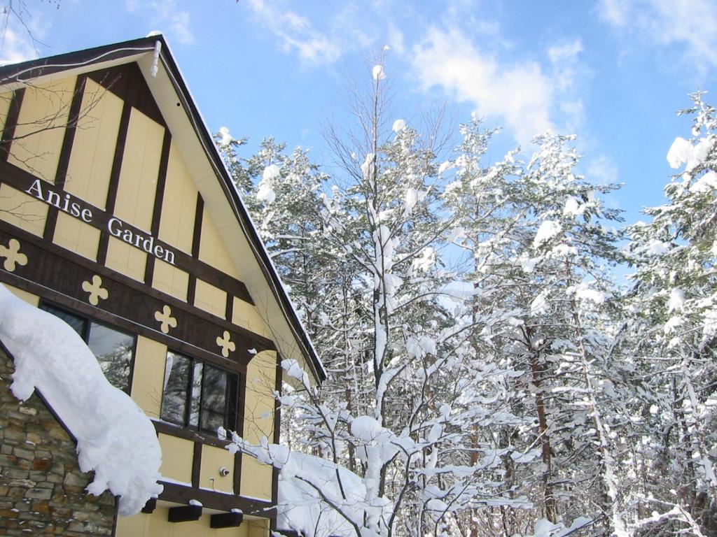 白马村艾尼斯花园宾馆的一座被雪覆盖的建筑,靠近一些树木