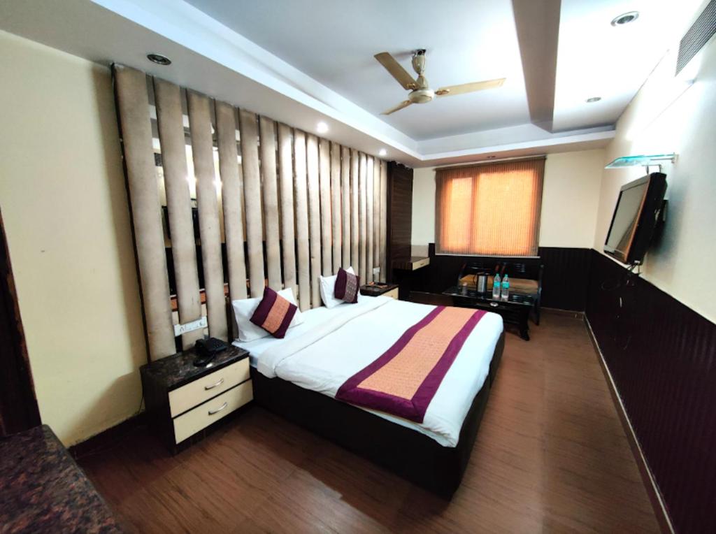 新德里Hotel The Gold Inn Karol Bagh Delhi的一间卧室配有一张大床和电视