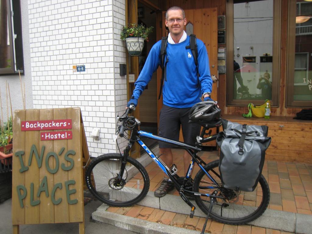札幌井野背包客旅馆的一个人站在自行车旁边