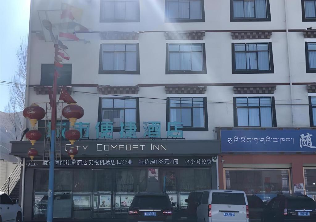 堆龙德庆City Comfort Inn Lhasa Gongga County Gongga Airport的车棚旅馆标志的高大的白色建筑