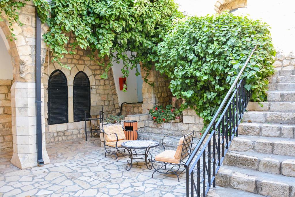 萨法德Ruth Safed By Dan Hotels的庭院设有桌椅和楼梯。