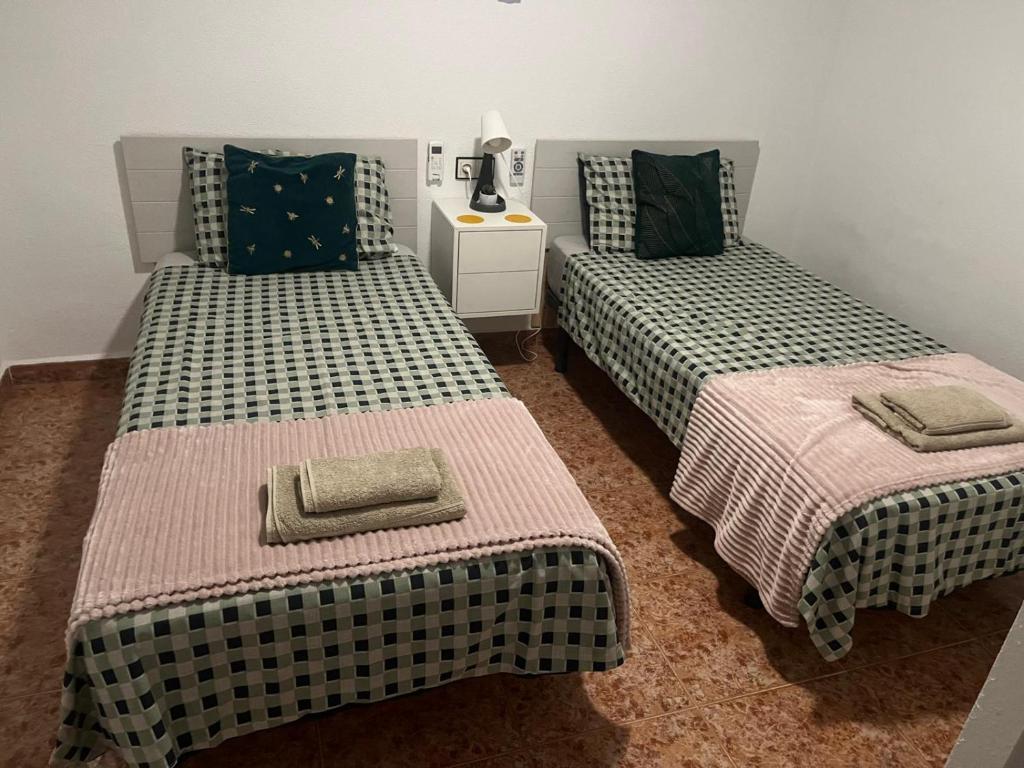 奥里韦拉Casa Sol Vistabella Golf Resort的两张睡床彼此相邻,位于一个房间里