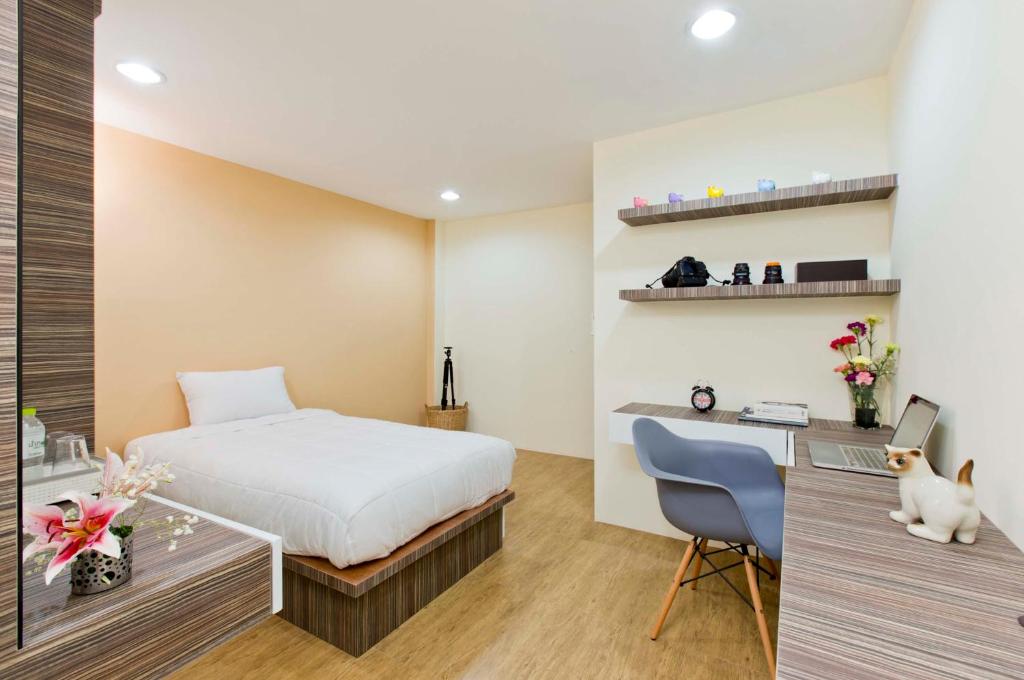 曼谷塔纳普密公寓的一间卧室配有一张床和一张带电脑的书桌