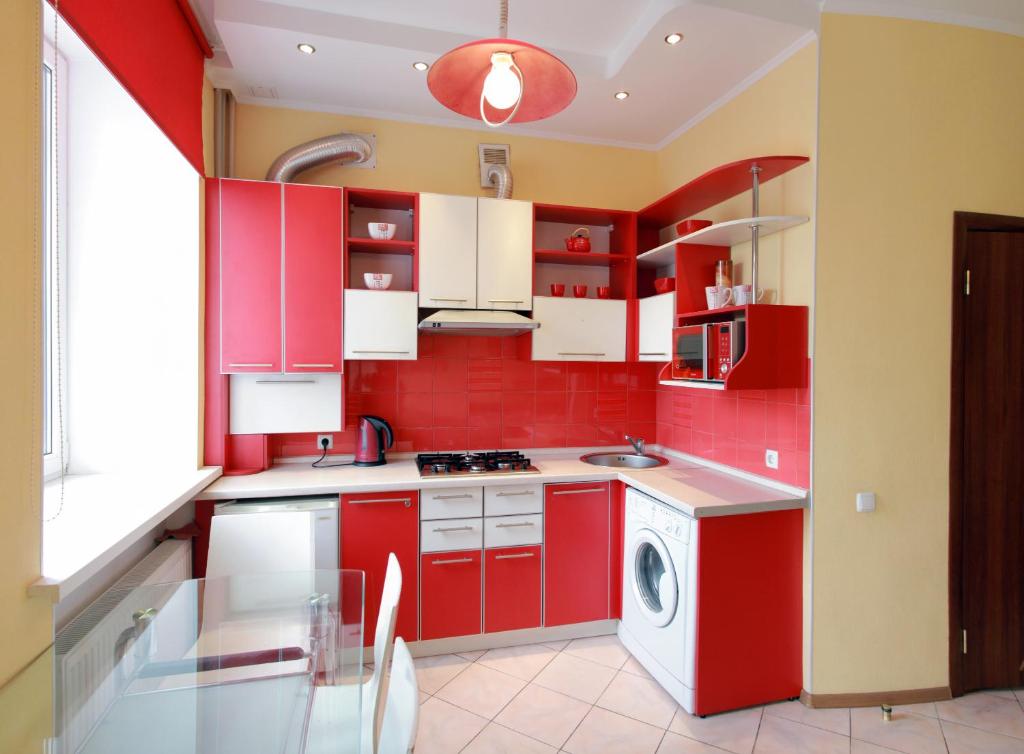 尼古拉耶夫VIP studio in CENTER!!!的红色的厨房配有白色橱柜和洗衣机