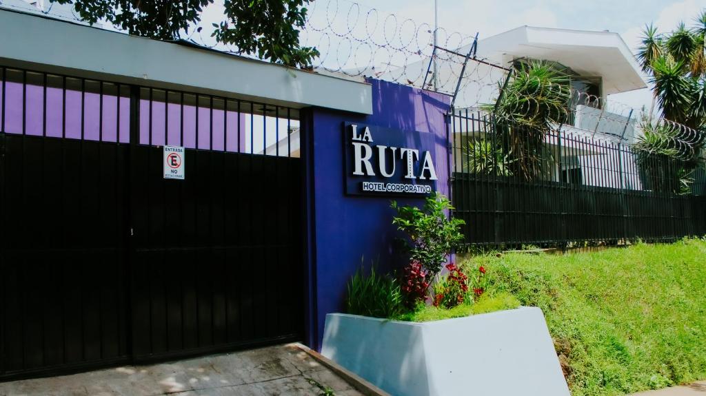 圣萨尔瓦多LA RUTA HOTEL CORPORATIVO的一座有黑色大门和标志的建筑