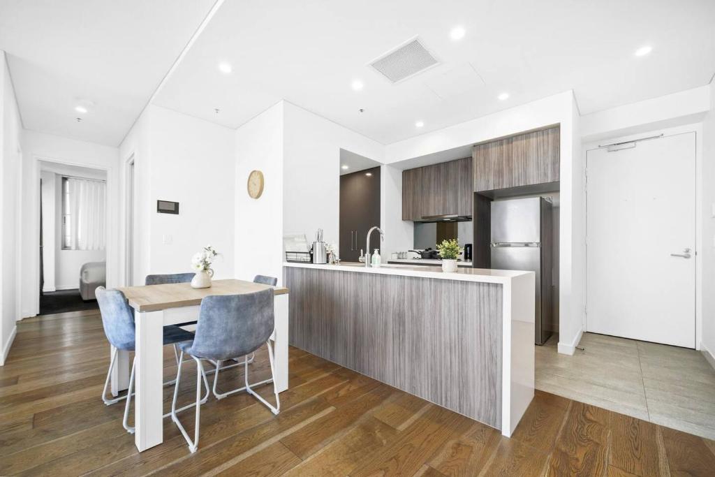 悉尼2BR Luxury Stay in Ultimo的厨房以及带桌椅的用餐室。