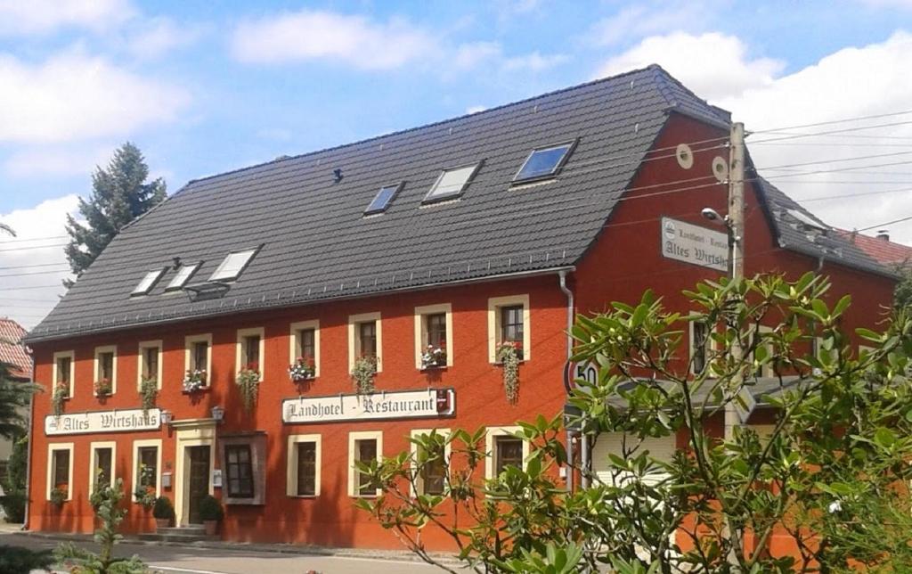 萨兰德特Altes Wirtshaus Fördergersdorf Bed & Breakfast的黑色屋顶的大型红色建筑