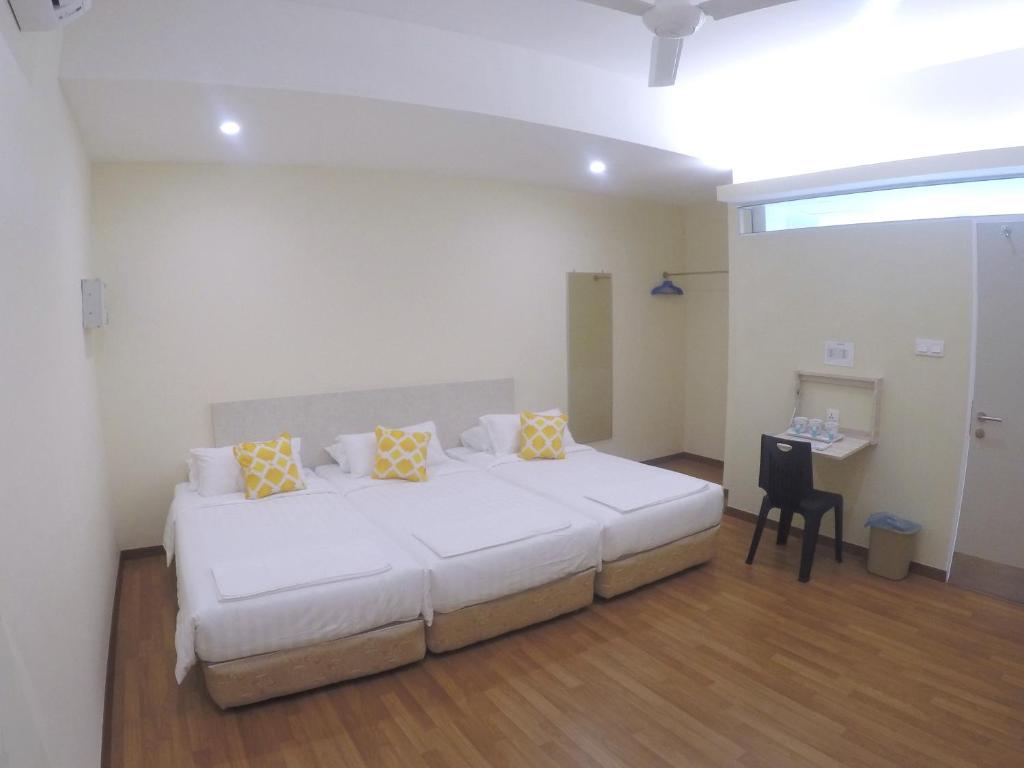 古晋1ACS Residence的卧室配有一张带黄色枕头的大型白色床。
