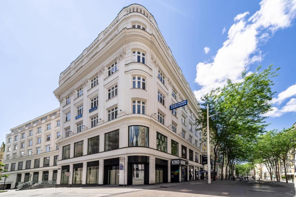 维也纳Hotel Corvinus Vienna - Newly Renovated的街道拐角处的白色建筑