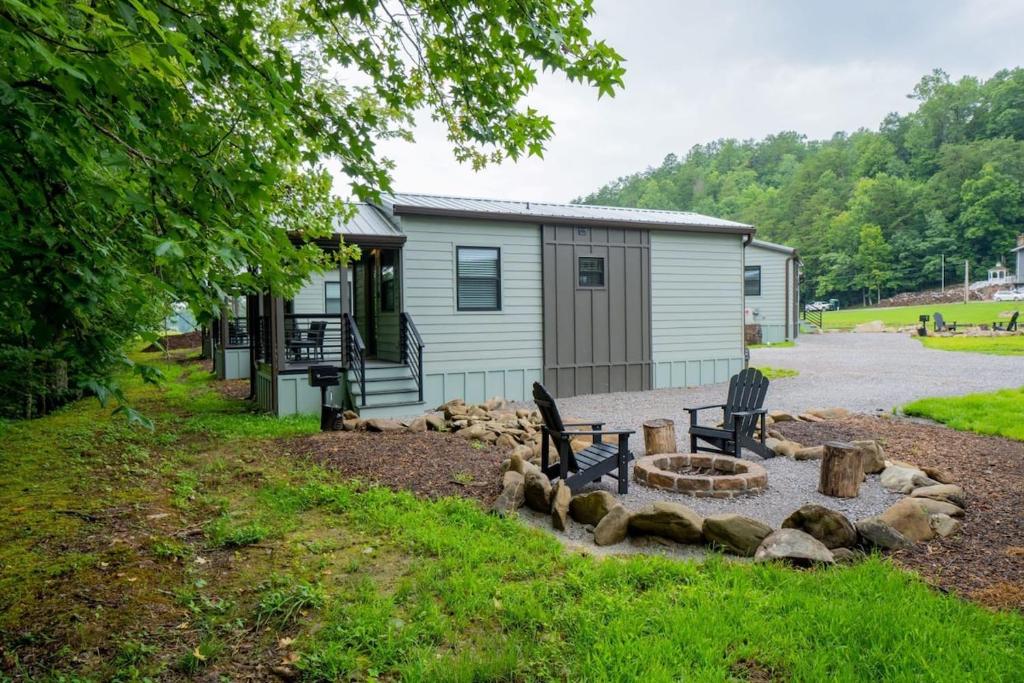 加特林堡Creekside Modern Tiny Home - Firepit - Racoon Cabin的建筑物前院落的火坑