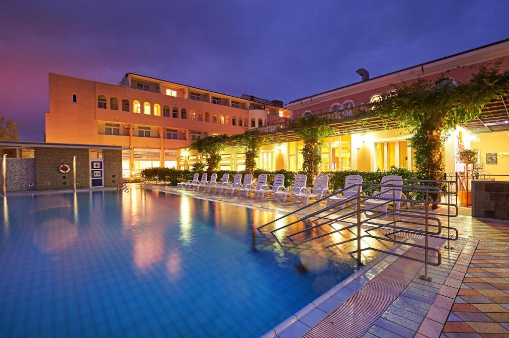 伊佐拉海豚酒店的一座带椅子的大型游泳池和一座建筑
