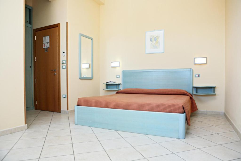 马洛塔马洛塔阿芭佳俱乐部酒店的一间卧室配有一张带橙色毯子的床