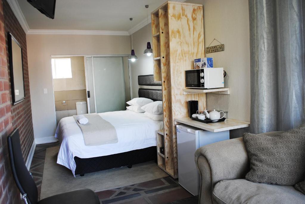 约翰内斯堡B and B Sandton的小型酒店客房配有床和微波炉