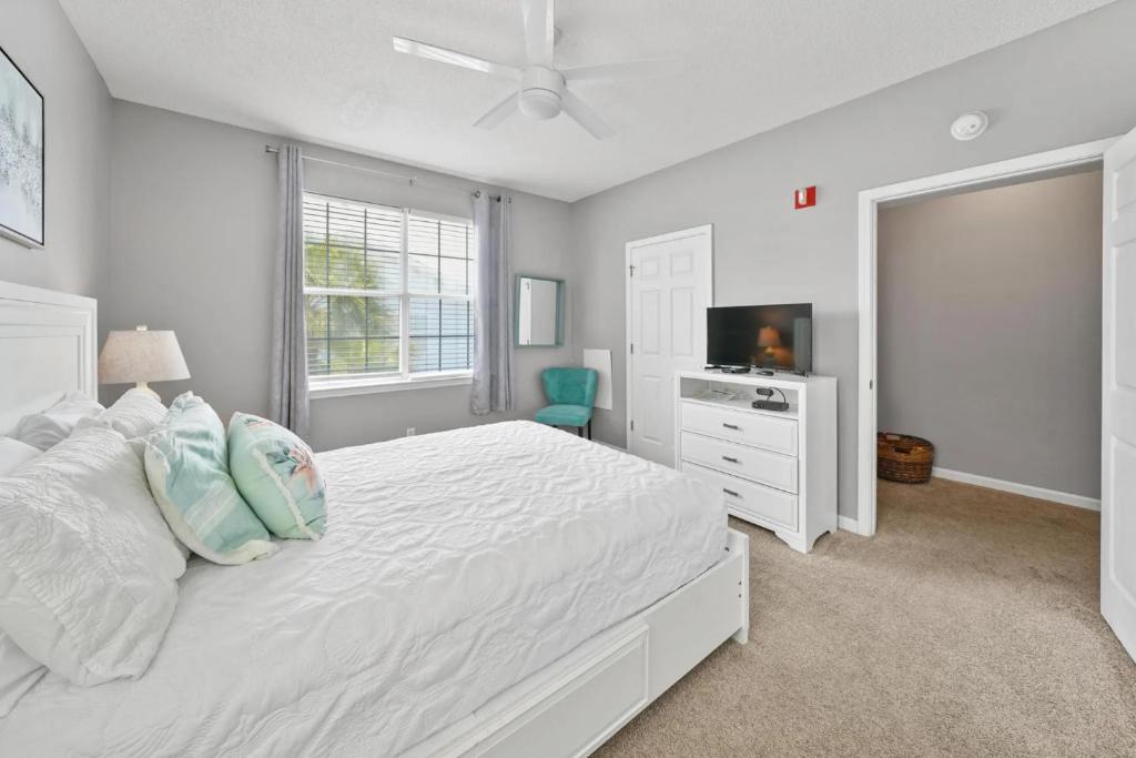 德斯坦Sunny escape in Miramar Beach的一间白色卧室,配有床和电视