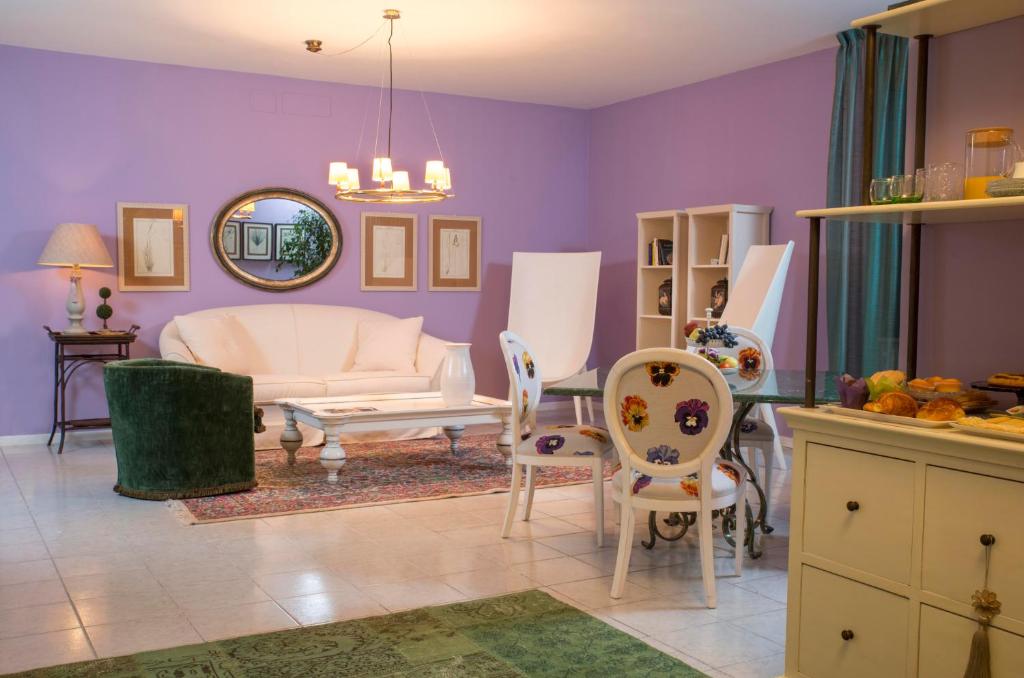 圣阿尔坎杰洛-迪罗马涅曼松毕格蒂住宿加早餐旅馆的客厅设有紫色墙壁和桌椅