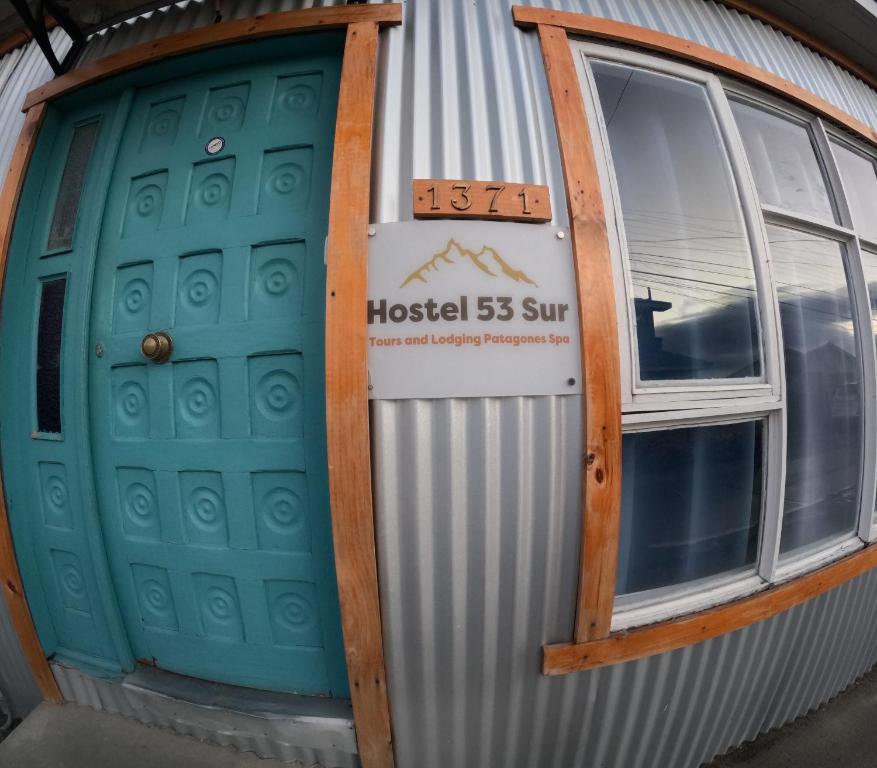 纳塔列斯港Hostel 53 Sur的一座有两扇门的建筑,上面有标志