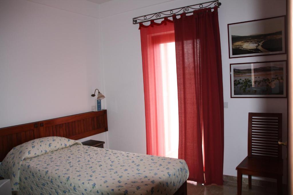 MiglionicoIl Ritrovo del Cima的一间卧室配有床和红色窗帘