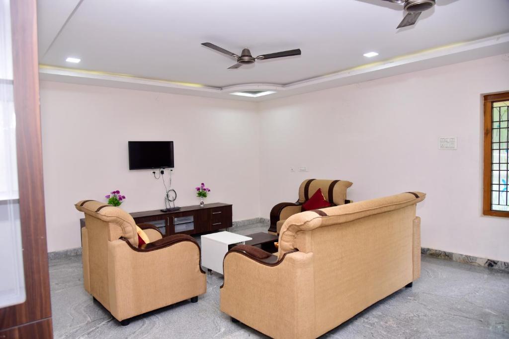 蒂鲁帕蒂SHALOM RESIDENCE - 2BHK-AC Service Apartments, Premium amenities, Kitchen with Stovetop, Free WiFi的客厅配有两把椅子和一张桌子