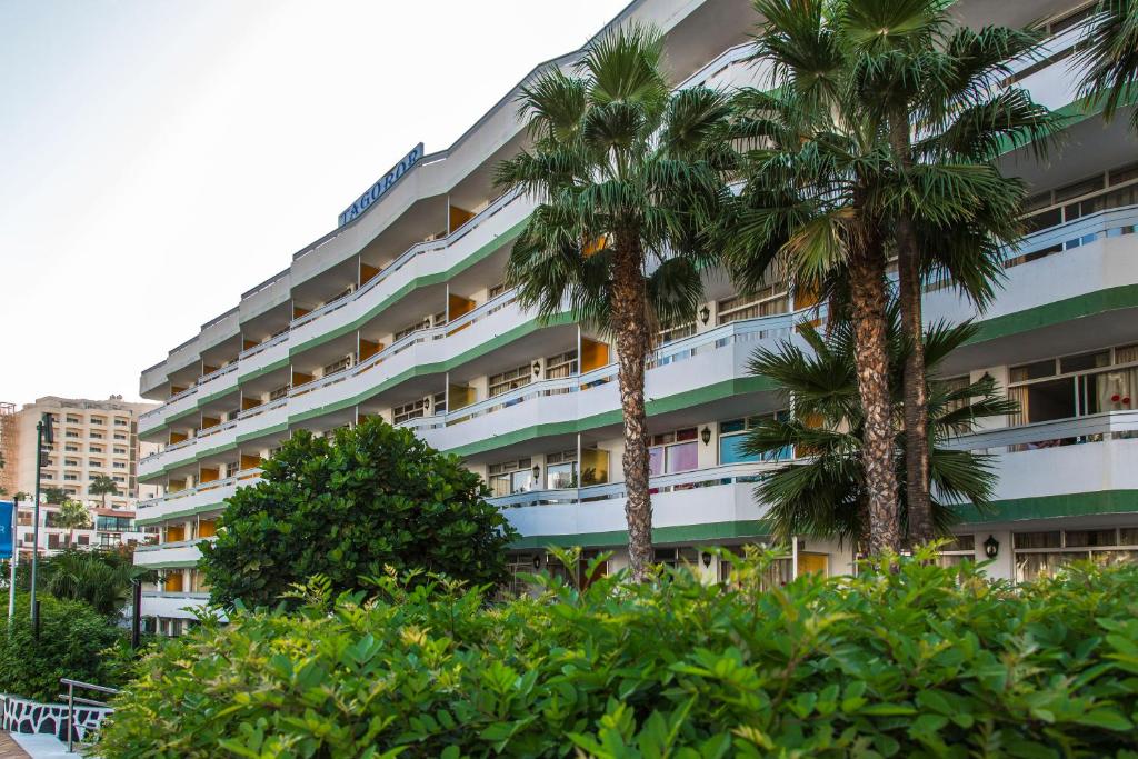 英格兰海滩Tagoror Beach Apartments - Adults Only的一座大型公寓楼,前面有棕榈树