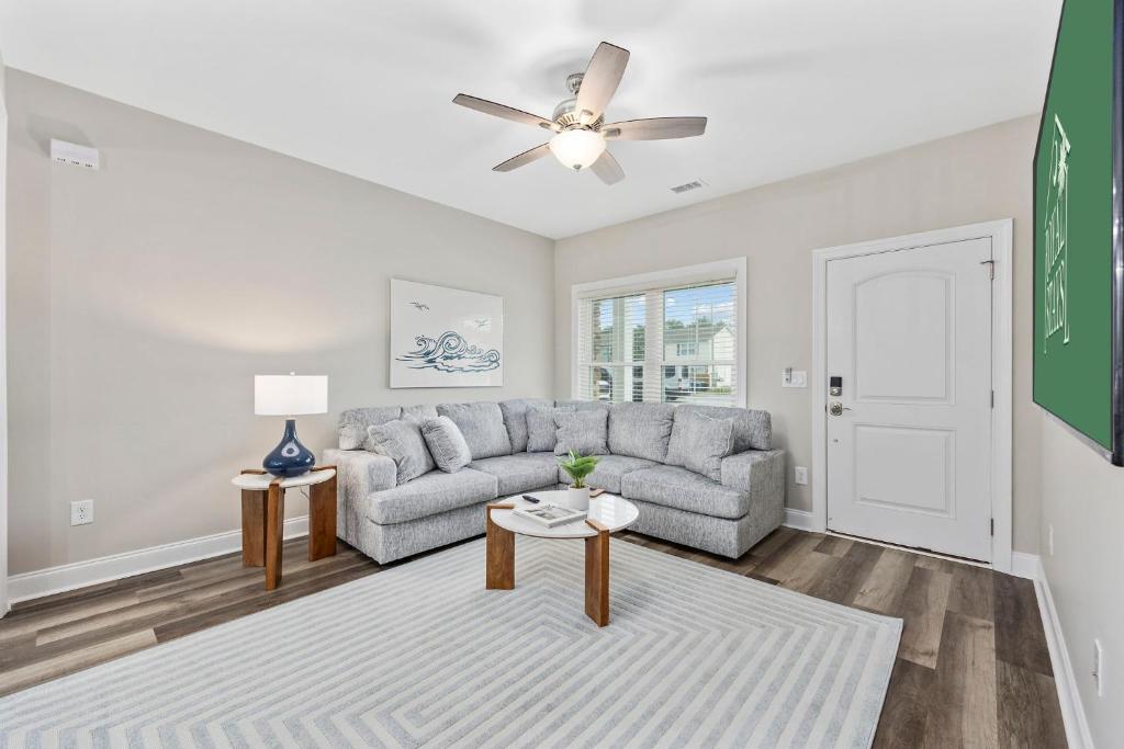 默特尔比奇Pier View - Spacious Home Sleeps 8 - Pet Friendly的带沙发和吊扇的客厅