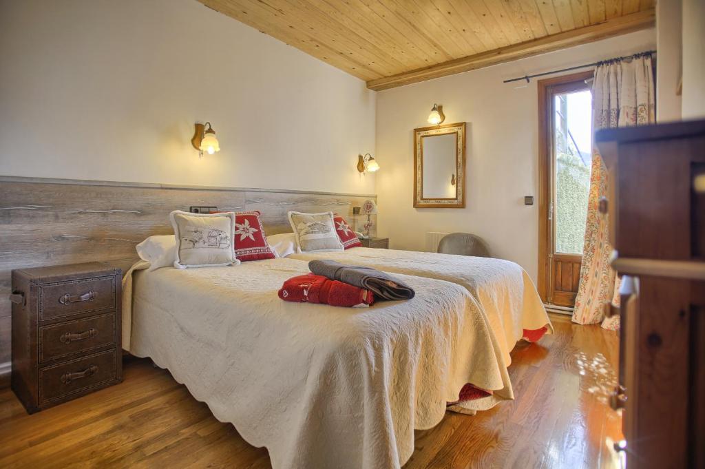 贝纳斯克San Marsial Benasque Apart Hotel的一间卧室配有一张带红色枕头的大床