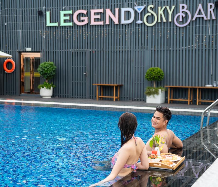 西哈努克Legend Hotel and Resort的坐在游泳池里的男人和女人