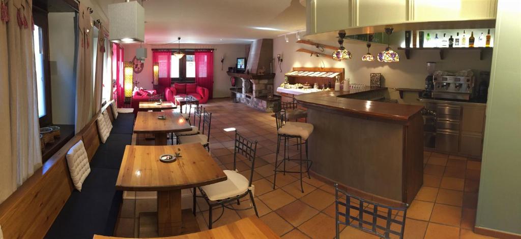 加洛斯Peira Blanca Hotel Gastronómico的一间带木桌的餐厅和一间酒吧
