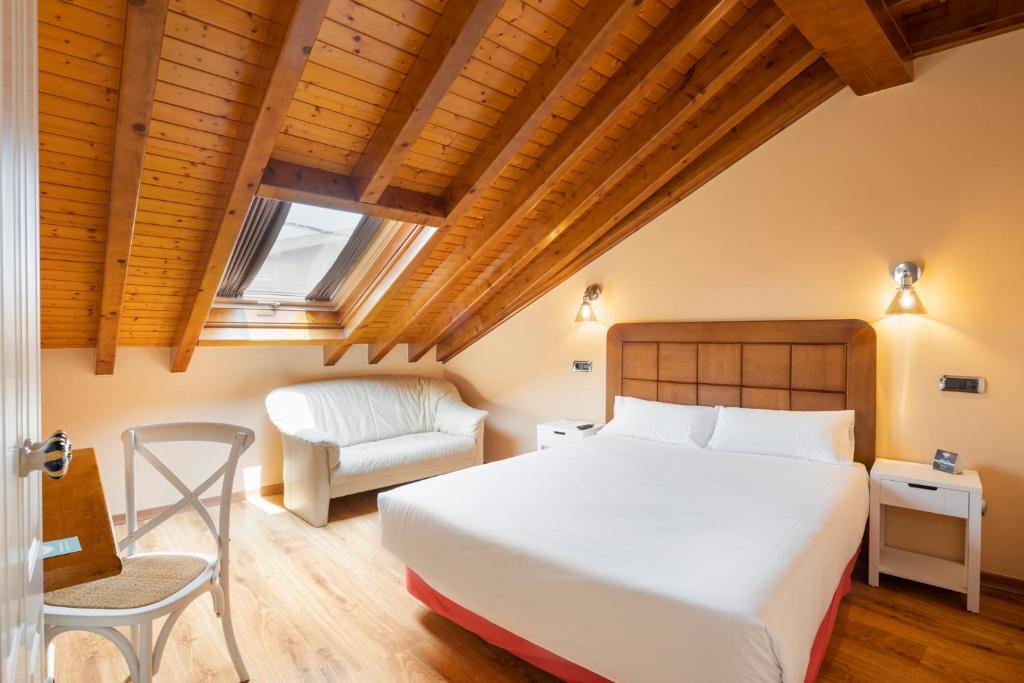拉林Hotel Alda Lalín的一间卧室配有一张床和一把椅子