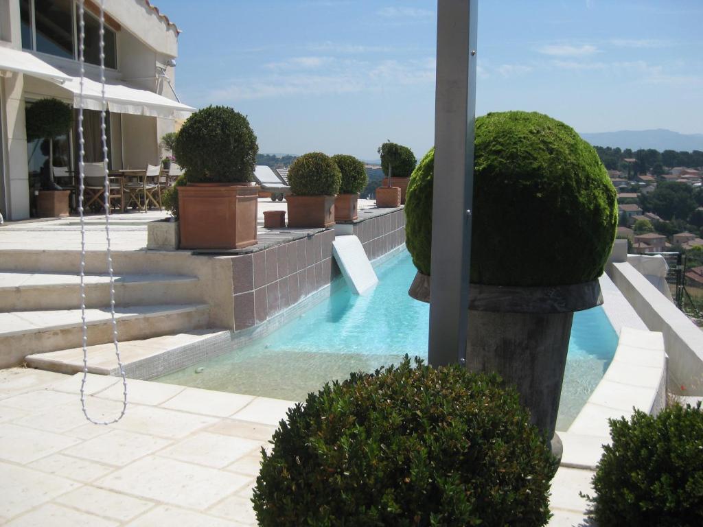 马赛布兰奇别墅酒店的一座植物繁茂的建筑的顶部游泳池